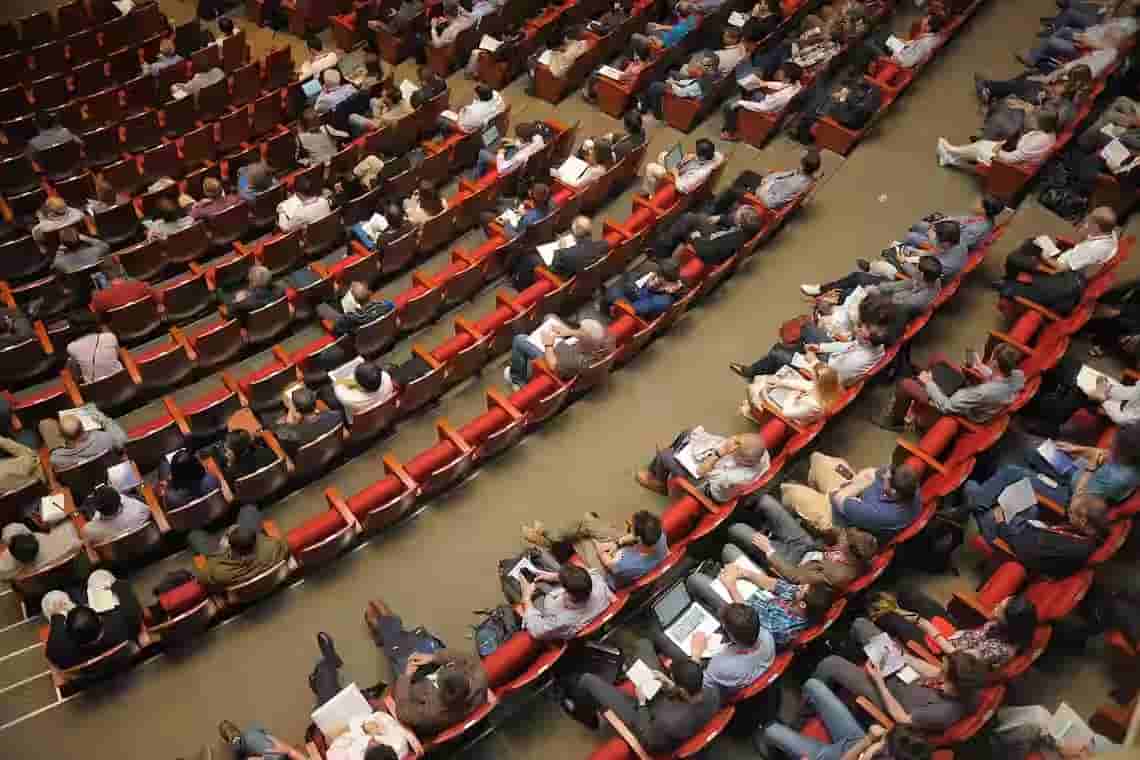 A large conference room viewed from above with a few empty seats.